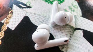 Oppo Enco Free2 earbuds lying on an album cover