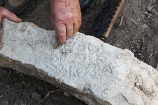 Archaeologists clean off one of the Aramaic inscriptions discovered in an ancient cemetery in Israel.