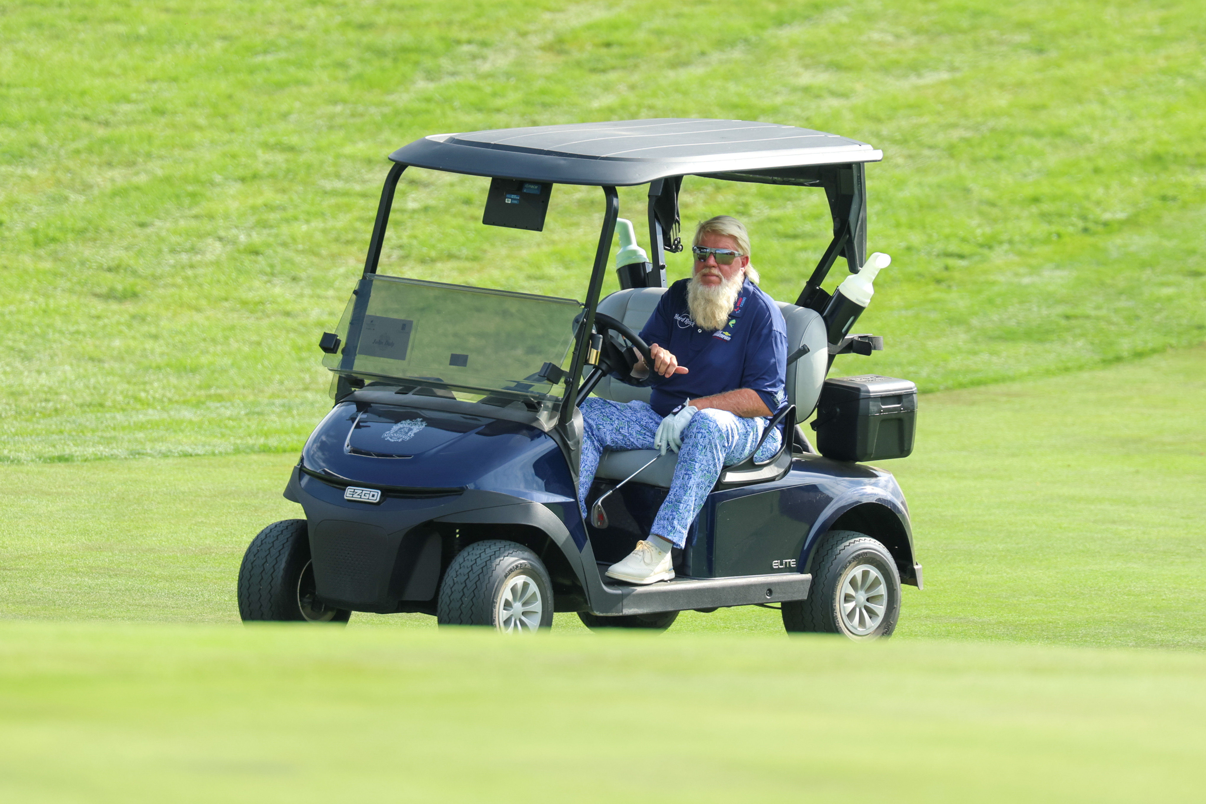 John Daly rides a cart