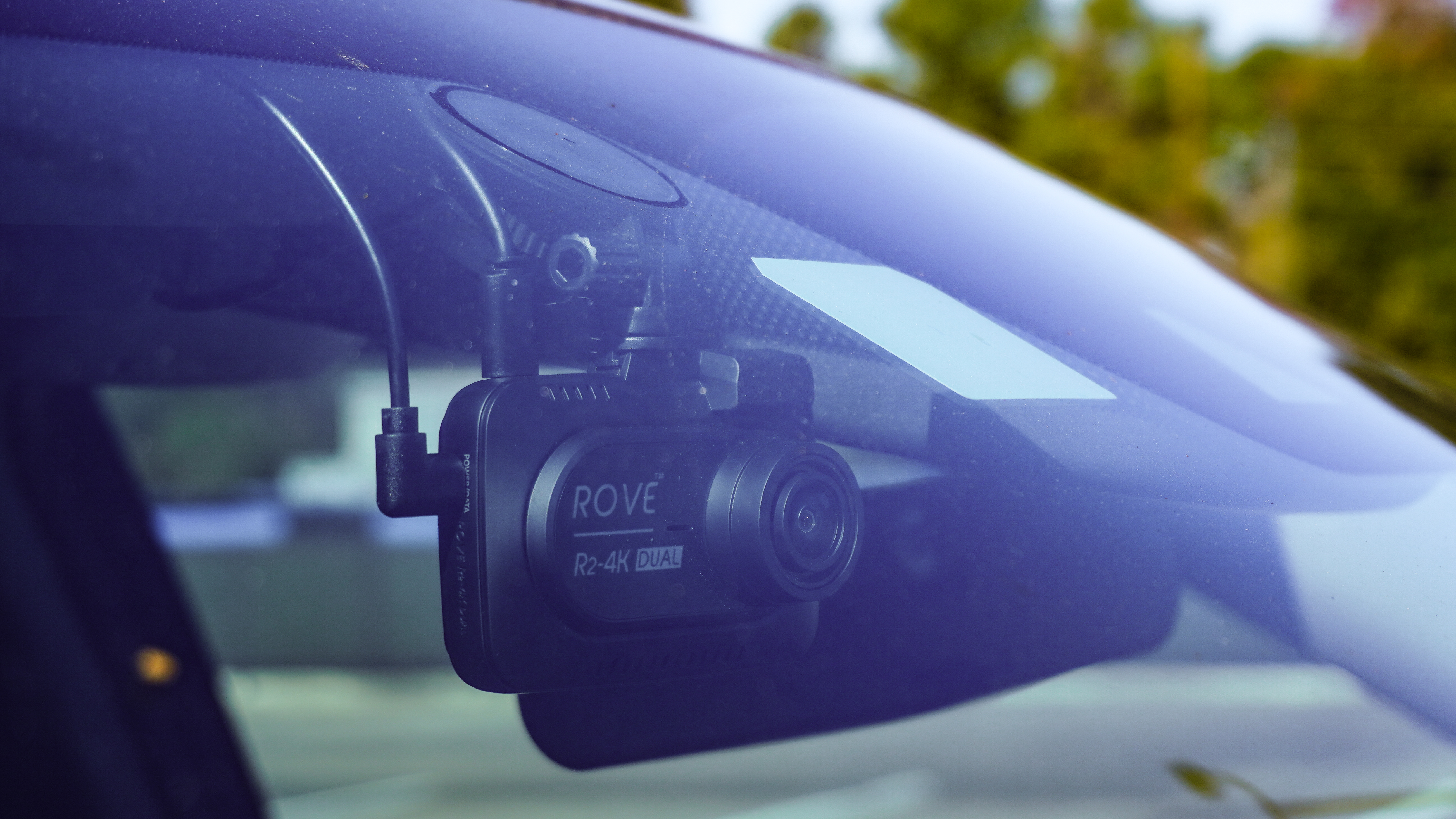 A close up shot of a Rove 2K-4K Dual dash cam installed inside a truck