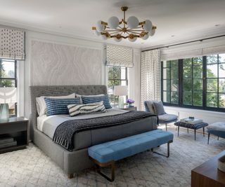 bedroom with gray upholstered bed and blue bench