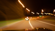 A blurry view from the driver's seat of a car at night