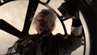 Christopher Lloyd on the clock in Back to the Future still from time travel scene.