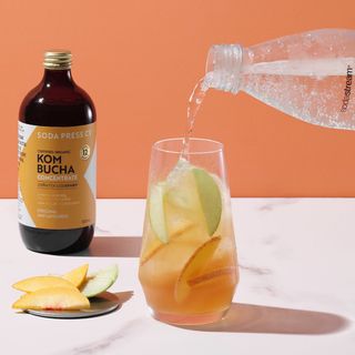 Kombucha syrup and a fresh drink on a white kitchen counter