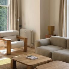 Living room with cream couch and stone wall