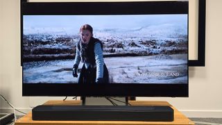 A picture of Damsel on Netflix on a TV screen – on-screen is a woman walking through a snowy landscape