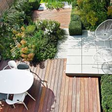 Small garden divided into zones using decking, paving and shrubs