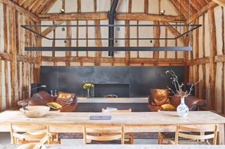 timber barn living room and dining room with modern steel fireplace