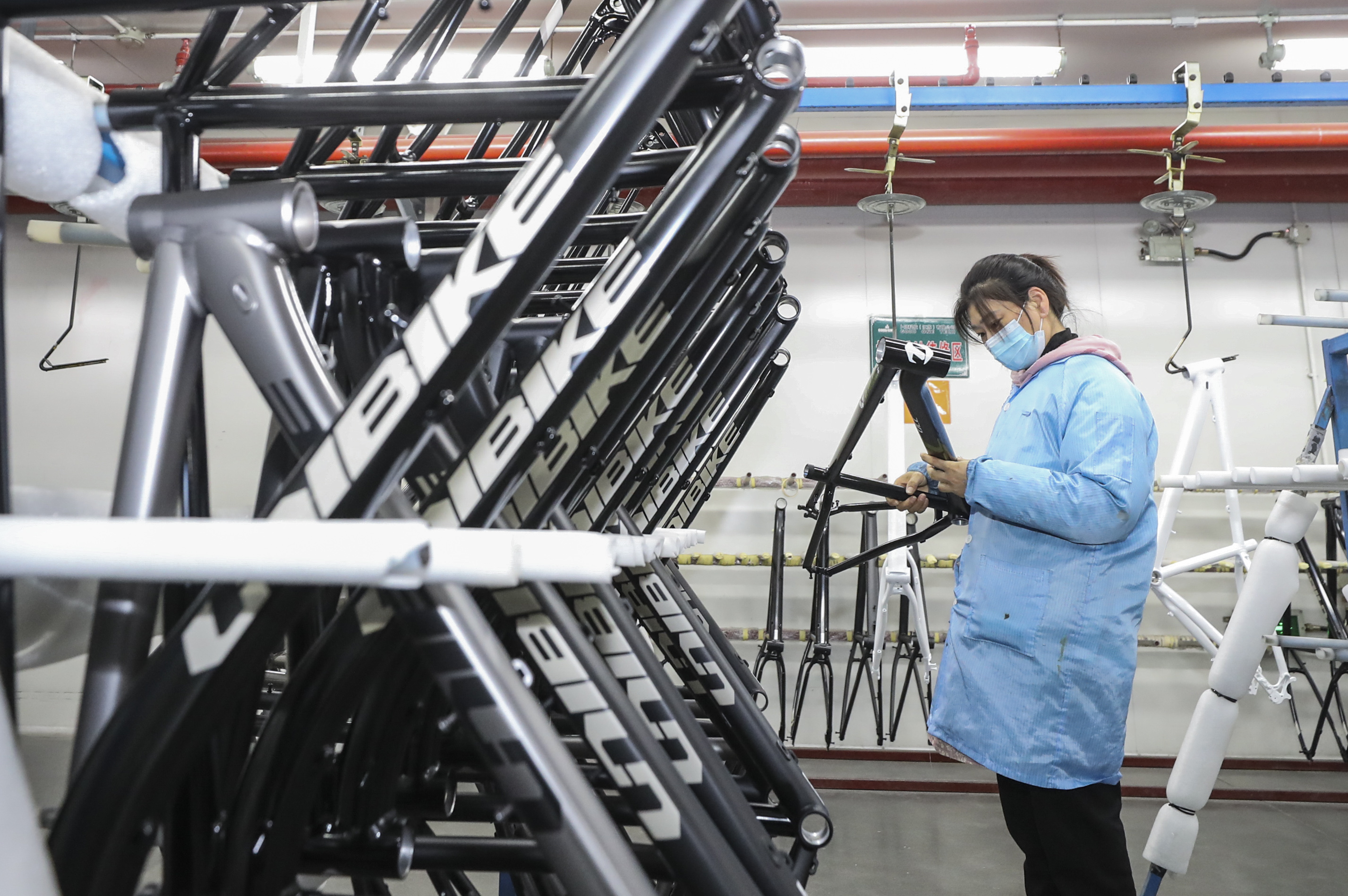 A worker is processing parts for a bicycle frame at a workshop in Huai'an, Jiangsu Province, China.