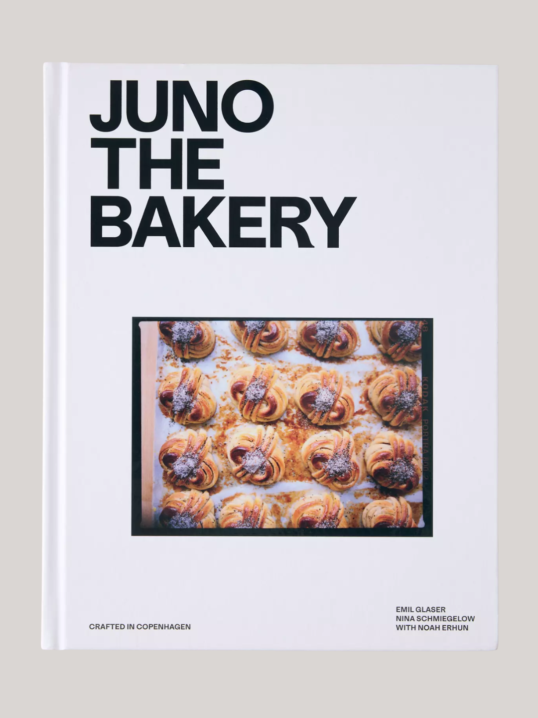 A hardcover white book titled 'Juno The Bakery' by Emil Glaser