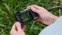 Panasonic Lumix L10 camera held in both hands with lens extended.