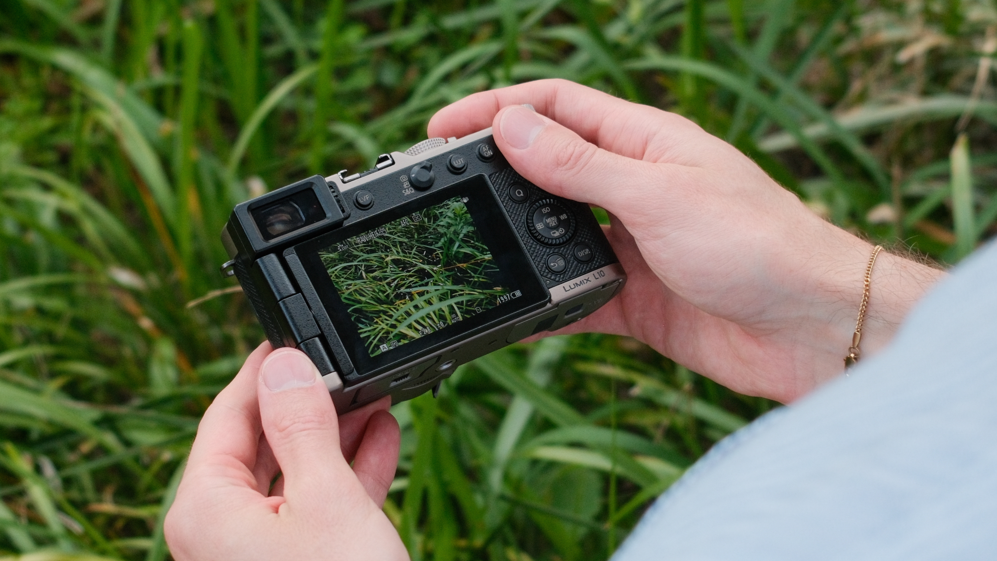 Panasonic Lumix L10 camera held in both hands with lens extended.