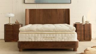 The Avocado Grand Luxe Mattress with pillow top on a wooden bed frame in a bedroom