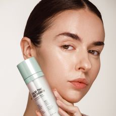 girl with rosacea holding innbeauty project calm the red down serum