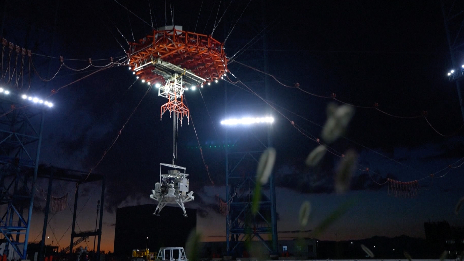 China's lunar lander, with four legs, floats down to the surface of Earth via parachute