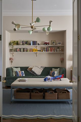 Small living room with beige walls and navy sofa with a blue painted coffee table and wicker storage