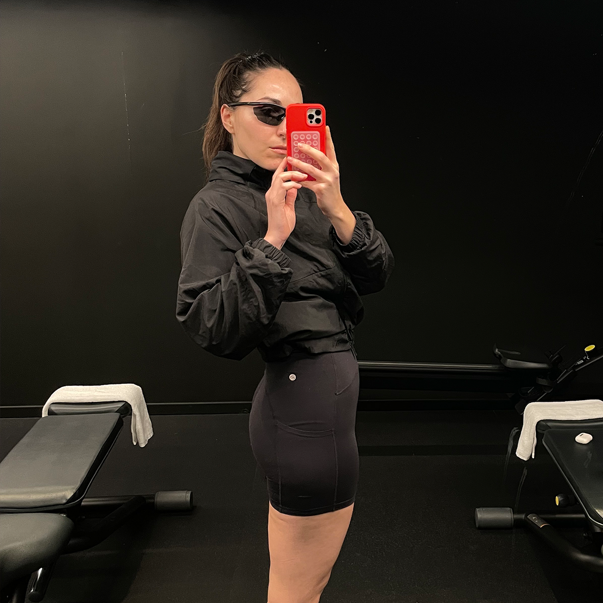 Who What Wear senior fashion editor Anna LaPlaca wearing a windbreaker and bike shorts at the gym