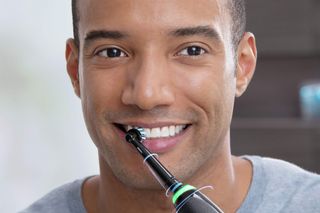 Man uses Oral-B Genius X electric toothbrush