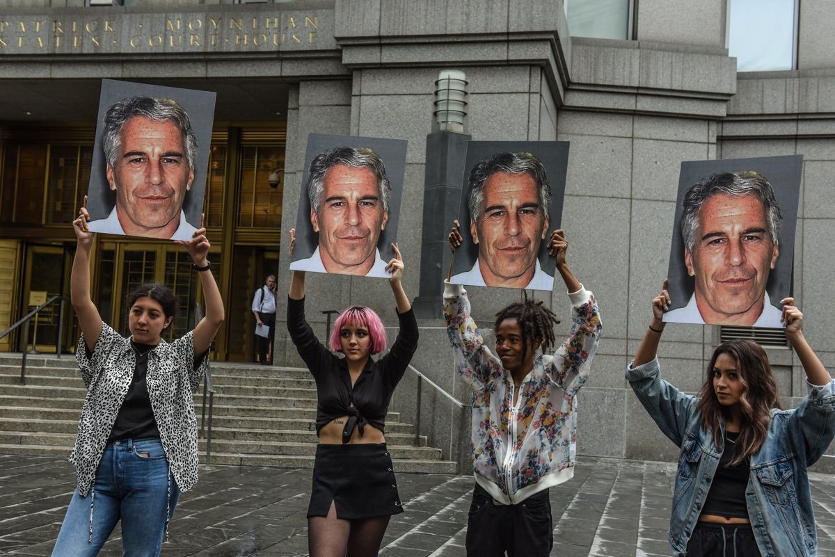 Members of a protest group hold up signs of accused sex trafficker Jeffrey Epstein, in front of the federal courthouse in New York City on July 8, 2019.