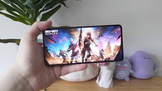 Hand holding Asus ROG Phone 9 with Call of Duty mobile loading screen displayed