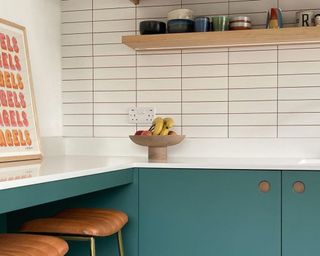 Kitchen with green-blue cabinets and white subway tile splashbacks