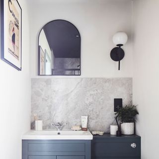 Downstairs bathroom with blue cabinetry and grey marble splashback