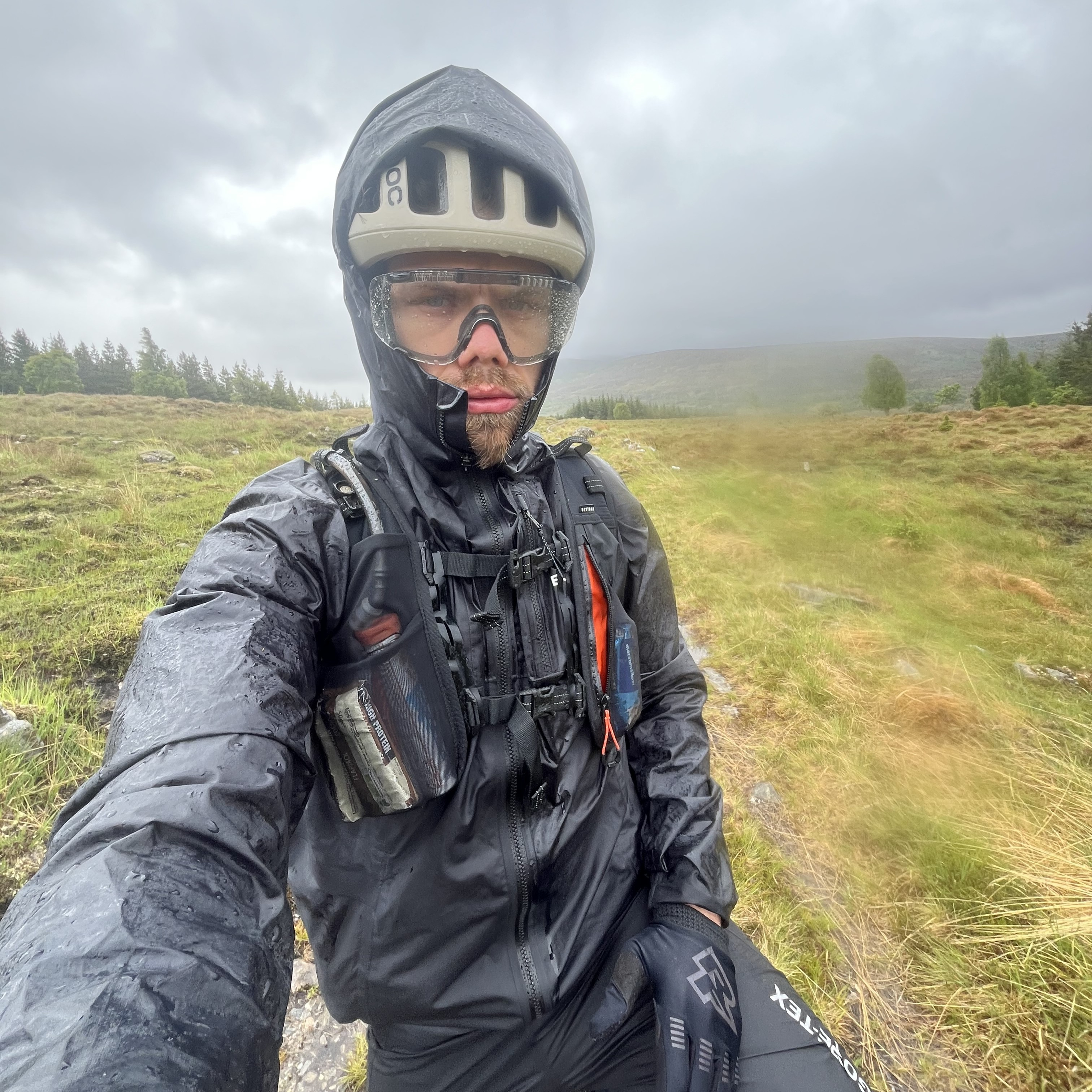 Graham wearing full waterproof kit standing in the pouring rain