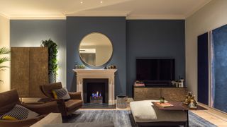 blue living room with stone fireplace and lighting scheme