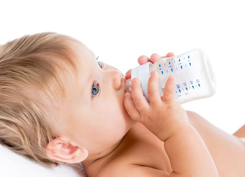 A baby drinks from a bottle.