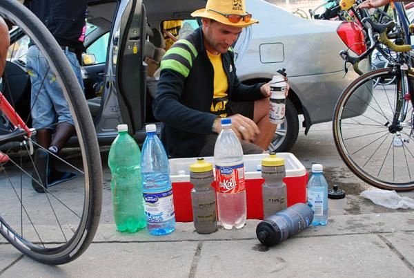 A soigneur takes care of his team's water bottles.