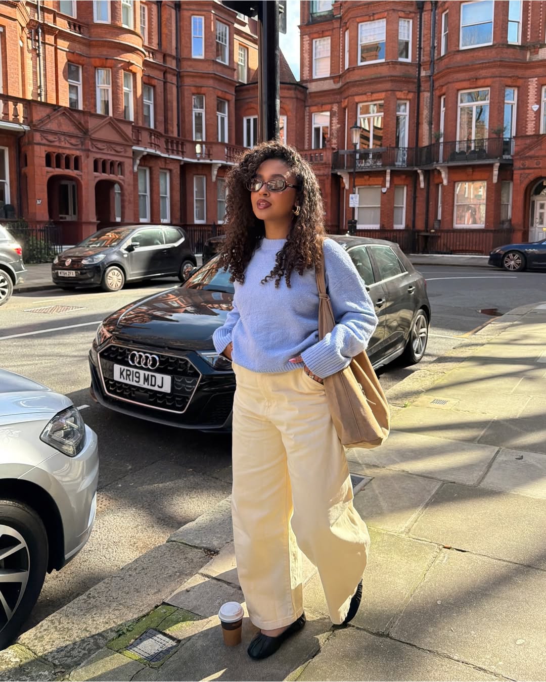 Influencer Layla Abbey wearing a pastel jumper, barrel-leg jeans and ballet flats.