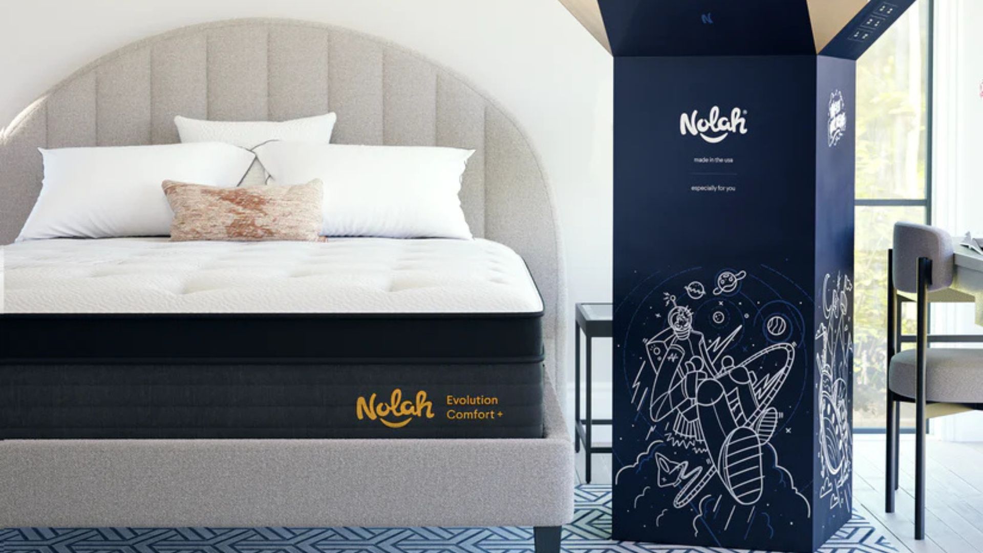The Nolah Evolution Comfort + Mattress on a gray bed frame. To the bed's right, the mattress's shipping box stands upright. 