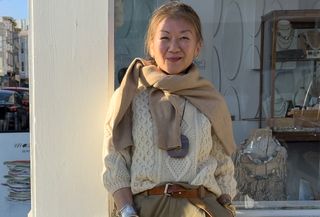 Irene Chen wearing a cable-knit sweater with a tan sweater around her shoulders.