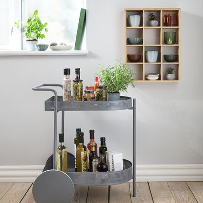 Wall shelf TOLNE 12 shelves bamboo and trolley in dining room