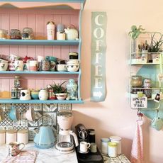 A pastel coloured kitchen with a coffee sign