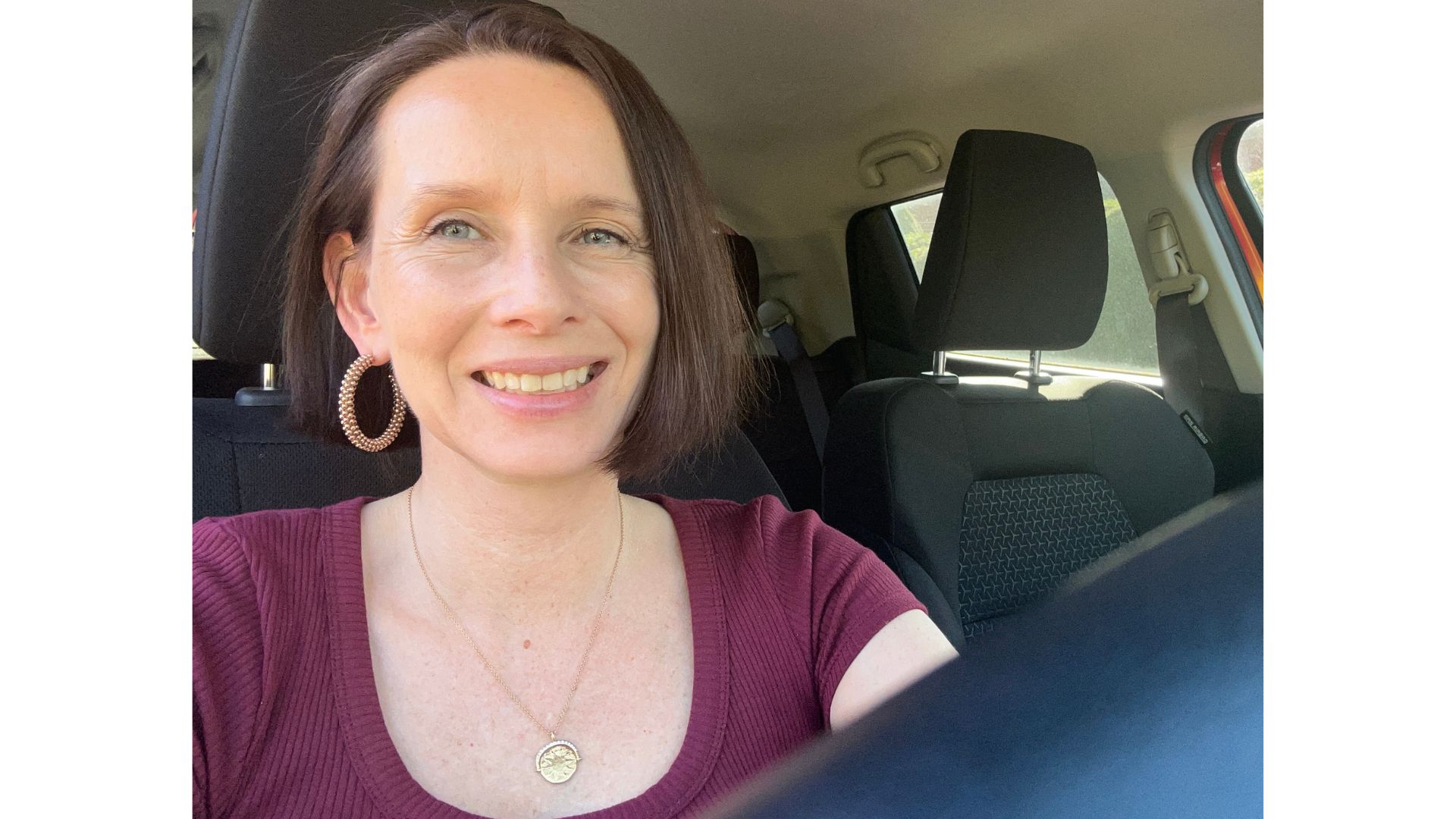 Michelle Rowley behind the wheel of her car, smiling