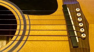A DIY rubber bridge on an acoustic guitar