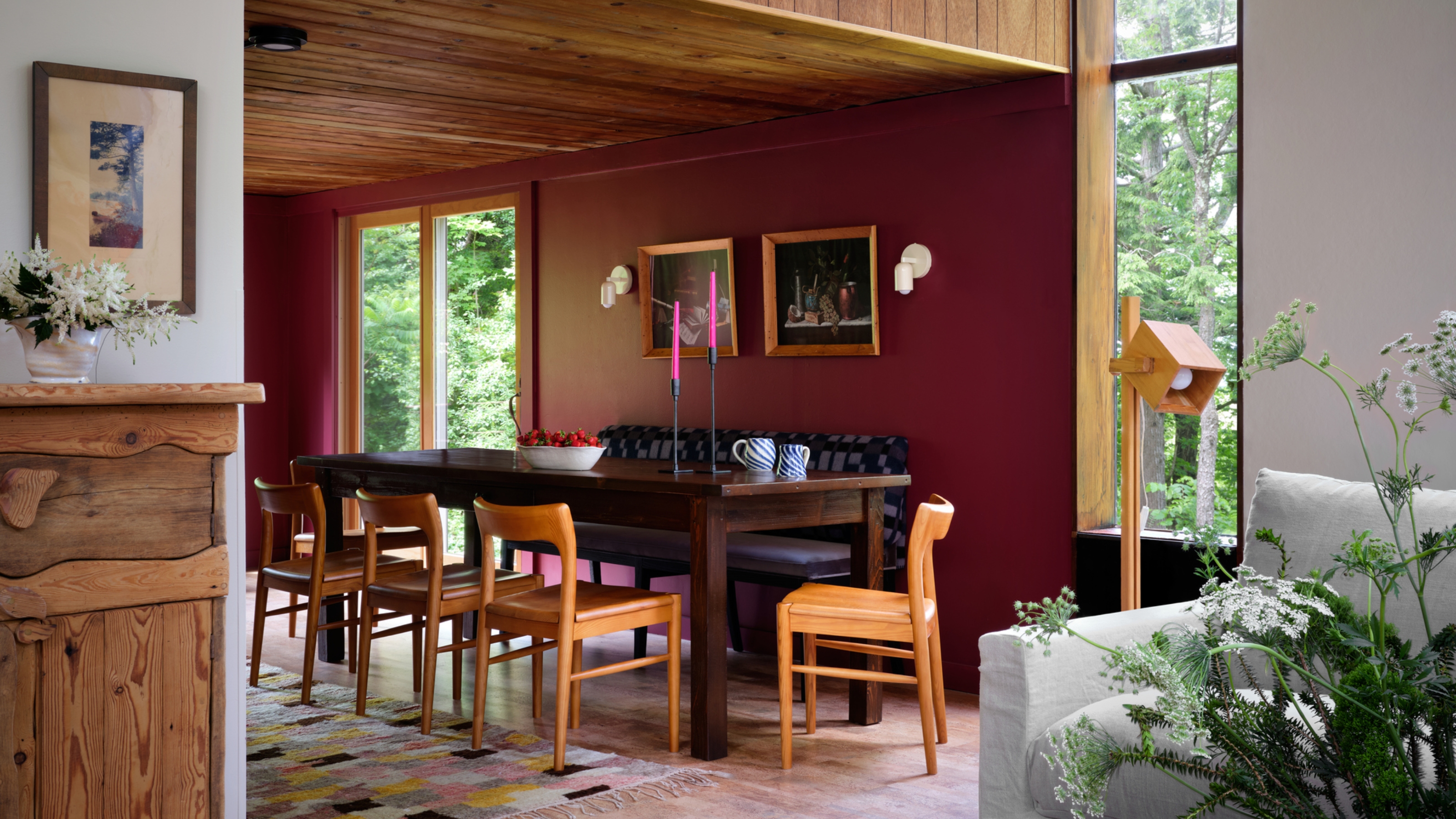 dining room with burgundy paint, timber ceiling, blue banquette seat and timber chairs around dining table