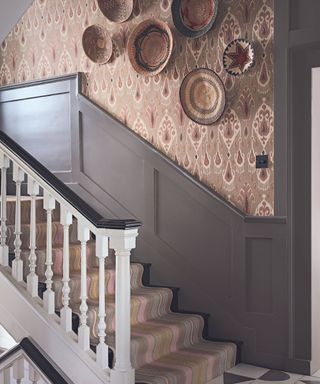 Staircase with striped runner, Indian inspired wallpaper and woven basket wall decoration