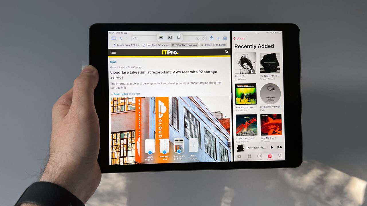 A photograph of the 12.9in 2021 Apple iPad Pro held in front of a wall