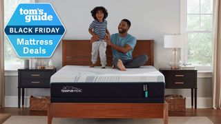 A father and child on a Tempur-Adapt mattress in a bedroom, with a Tom's Guide Black Friday Mattress Deals badge overlaid