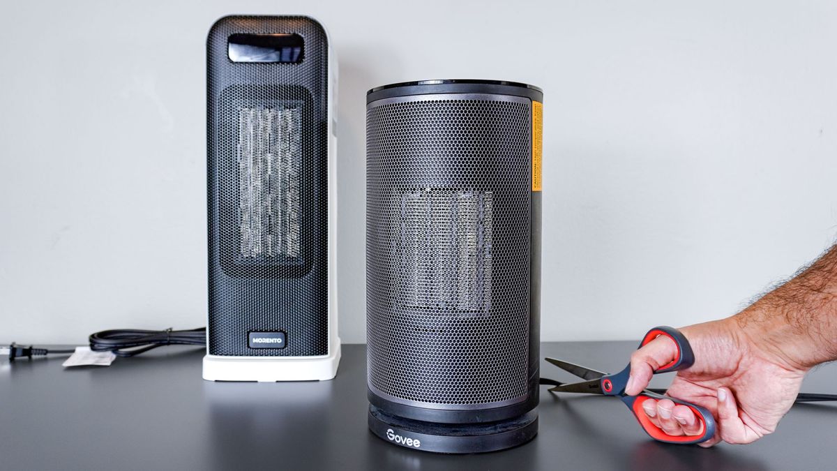 A picture showing a person cutting the electrical cord on a recalled smart space heater with a new smart space heater in the background