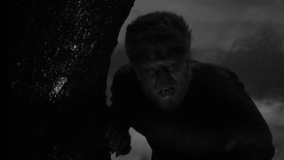 The Wolf Man stalks a forest at night in The Wolf Man