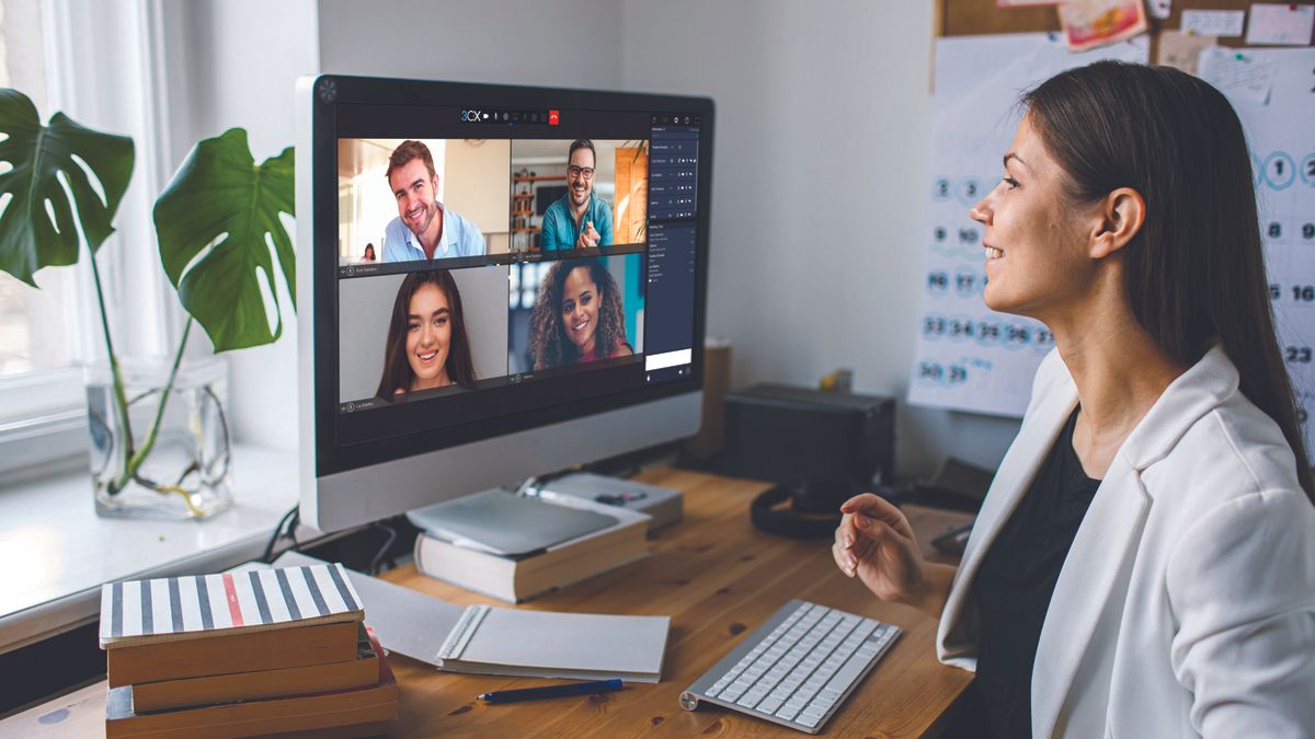 A women sits at her desk on a video call