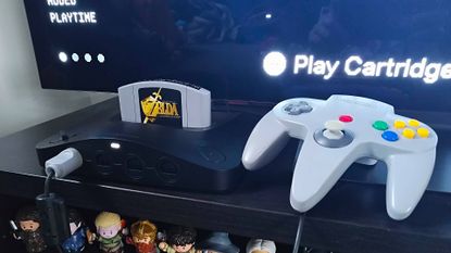 Analogue 3D with Zelda: Ocarina of Time inserted next to original grey controller.