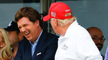 Carlson laughing with Trump at Trump National Golf Club in July 2022