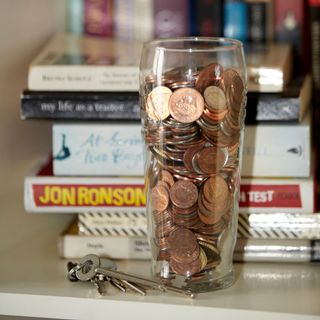 glass with copper coins books and keys
