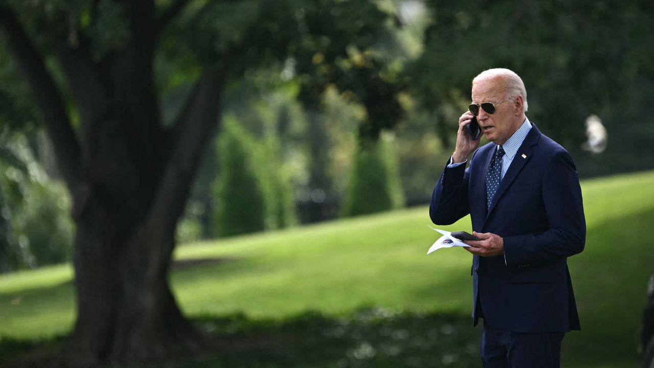 President Joe Biden talks on the phone outside the White House 