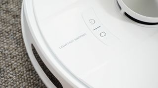 The EZVIZ RE4 Plus robot vacuum in a carpeted living room