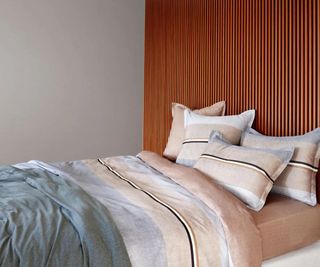 Iconic Stripe Bedding on a bed against an orange wall.